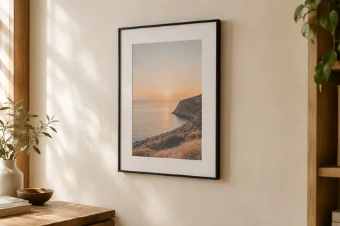 Cadre photo A4 noir à profil fin, avec passe-partout, accroché verticalement sur un mur crème.